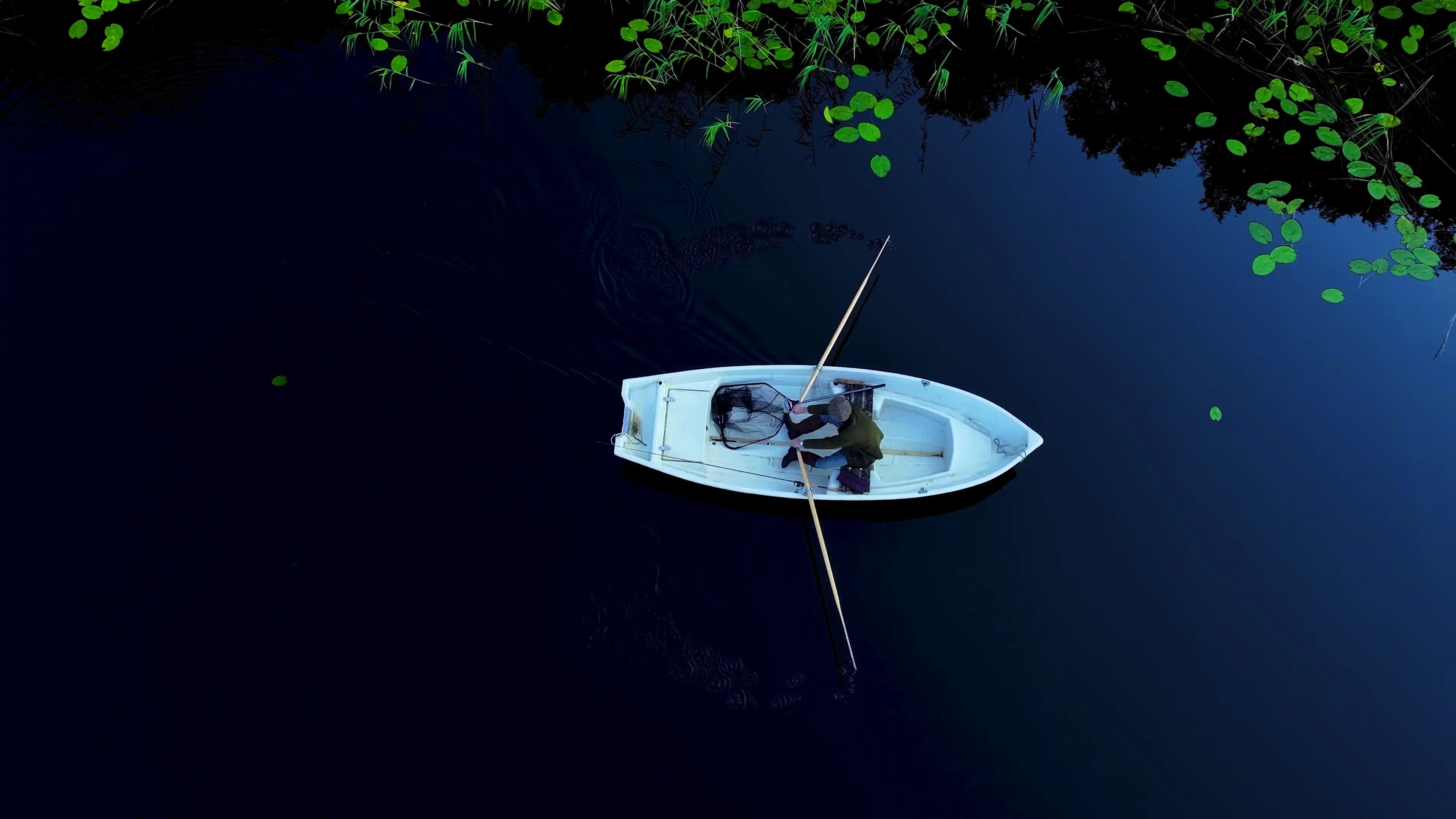 Fisherman rowing and casting high-performance Esox Lures fishing lures on a sunny day